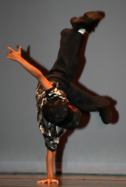 Boy doing a one arm handstand